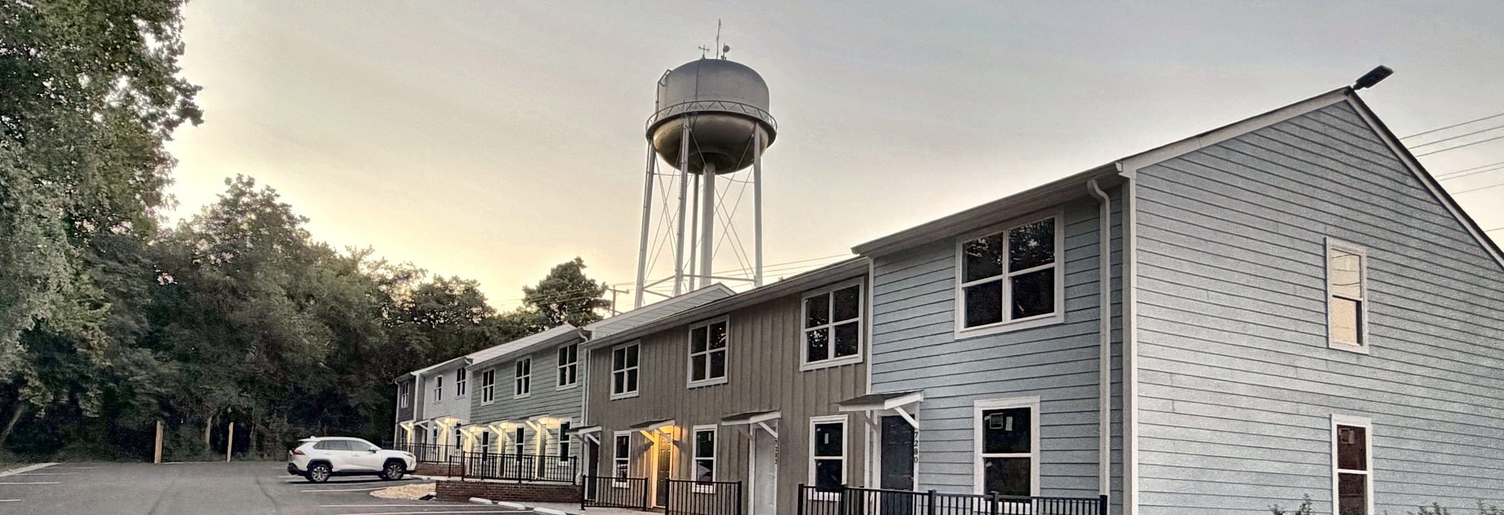 Courthouse Commons townhomes at dusk with the Gloucester water tower behind them